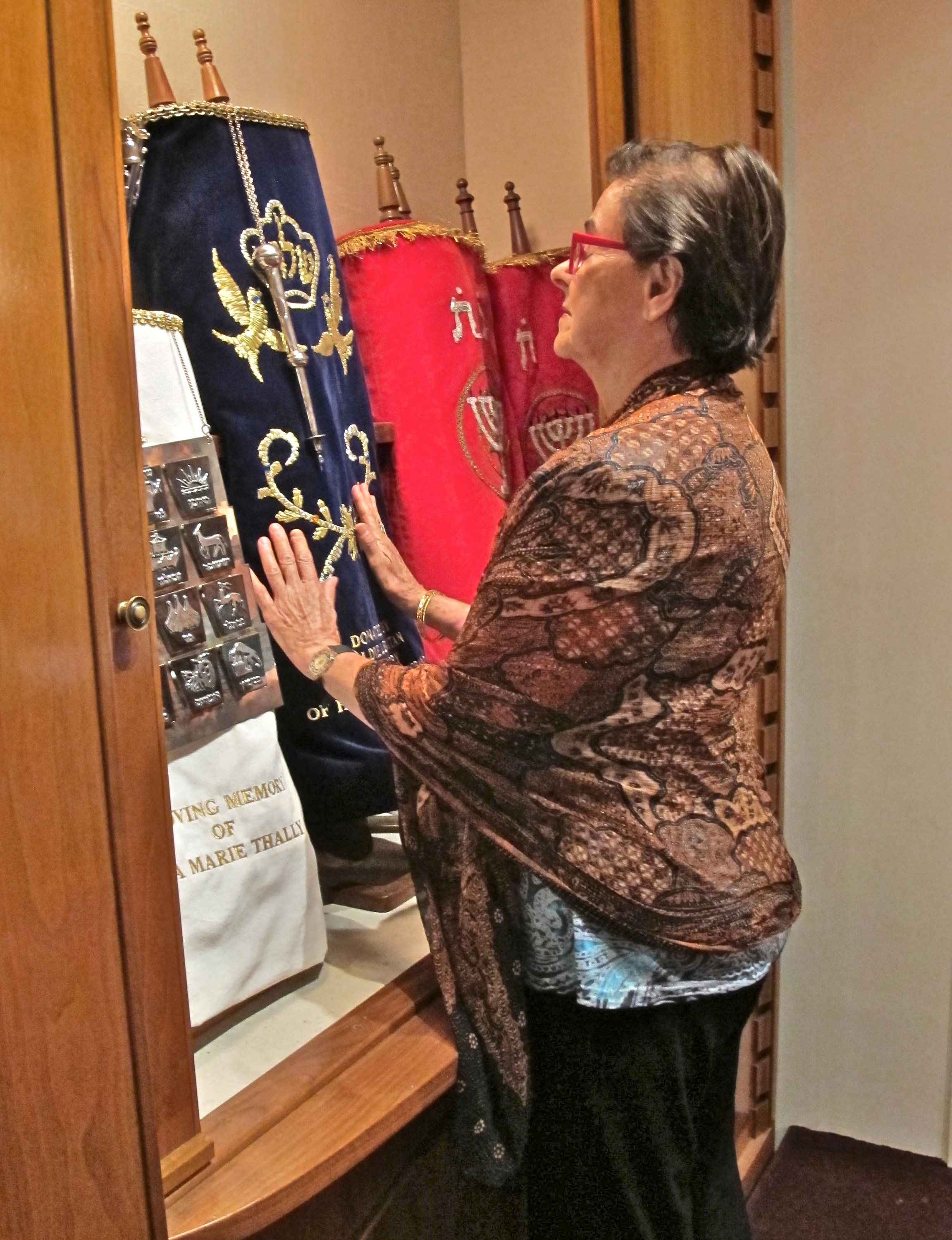 Woman touching the Torahs.